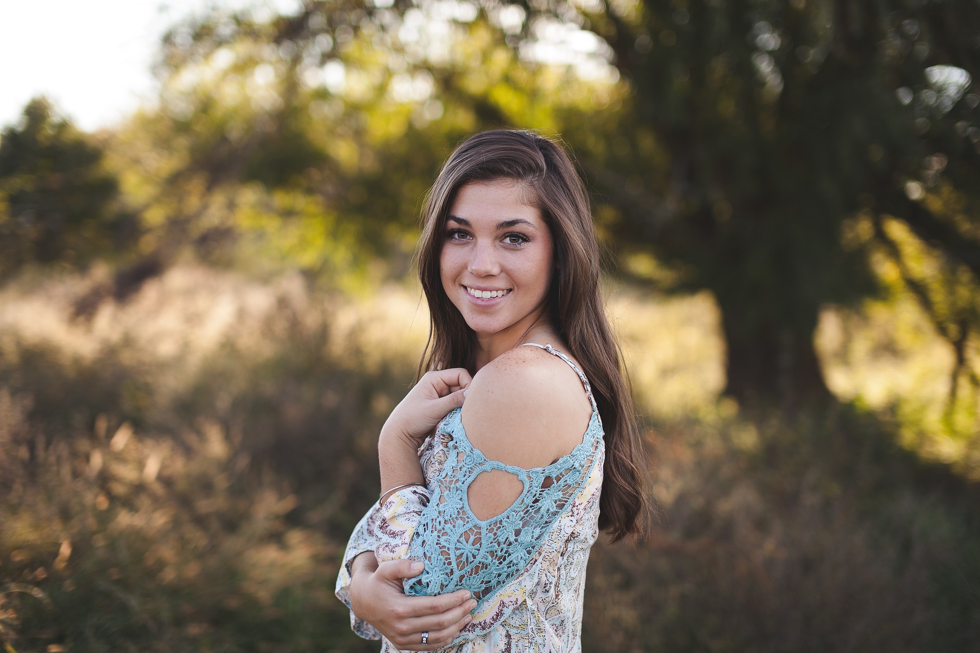 A young smiling woman standing in a field